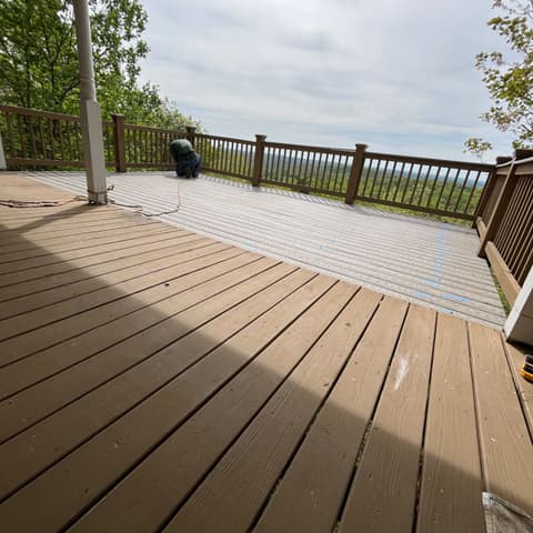 Dark-stained deck boards and rail overlooking the mountains