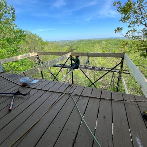 Deck rebuild with new joists in place, looking out over the treetops