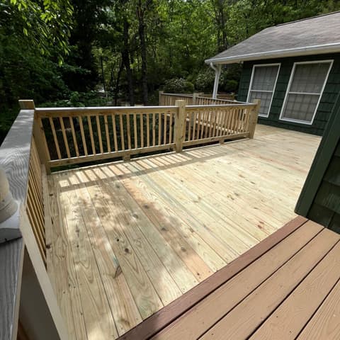 Finished pressure-treated deck and rail on a green cottage